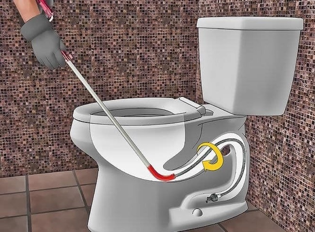 Xử lý bồn cầu bị tắc vật cứng bằng dây thông tắc